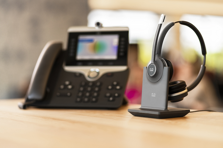 Das Cisco 562 Headset auf der Standard Base Station neben dem Cisco 8865 IP-Telefon