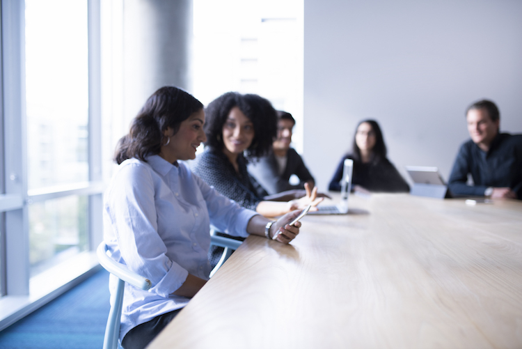 Ein Team sitzt am Meetingtisch und unterhält sich