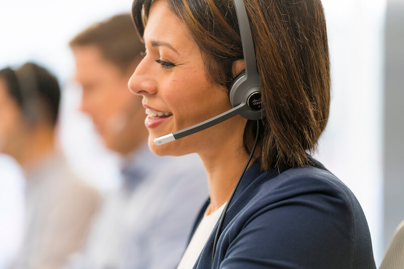 Eine Frau telefoniert über das Headset im Büro