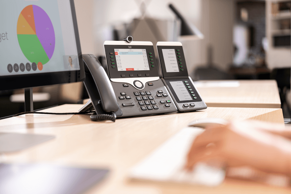 Das Cisco 8865 IP-Telefon mit Videofunktion steht auf dem Schreibtisch